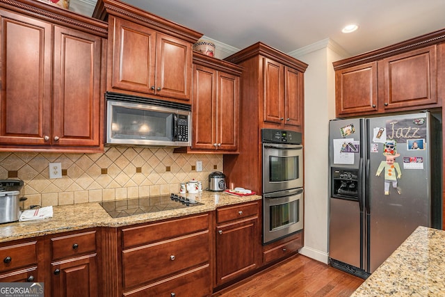 kitchen featuring light stone counters, ornamental molding, appliances with stainless steel finishes, backsplash, and dark wood finished floors