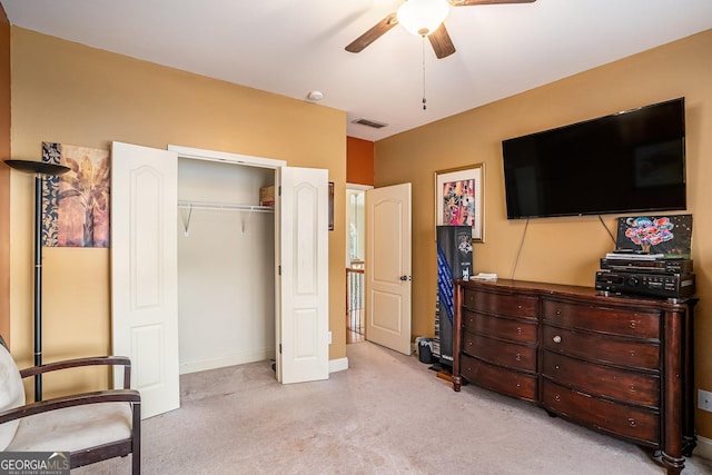 bedroom with ceiling fan, light colored carpet, visible vents, baseboards, and a closet