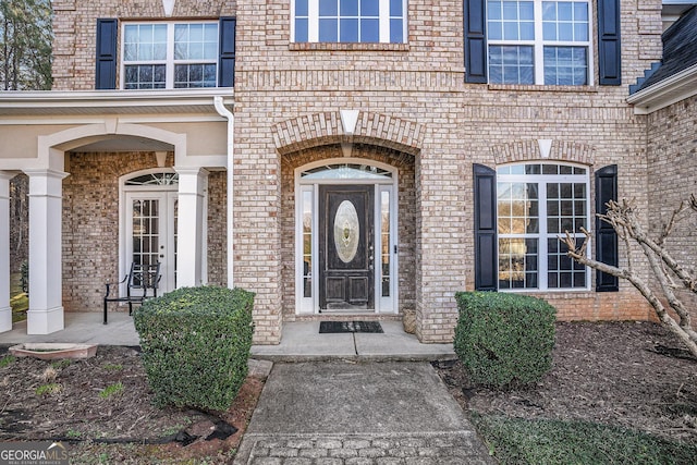 entrance to property featuring brick siding