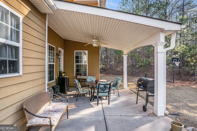 view of patio featuring area for grilling, a ceiling fan, and outdoor dining space