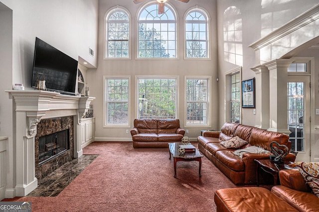 living room featuring a high ceiling, a fireplace, visible vents, baseboards, and carpet