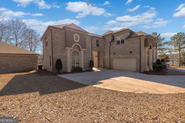 mediterranean / spanish home with driveway, brick siding, and an attached garage