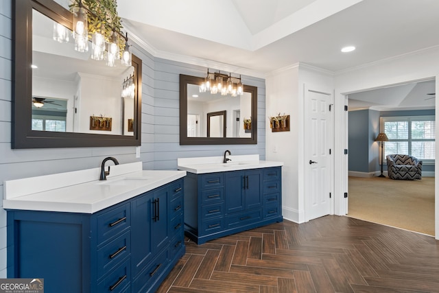 full bathroom with baseboards, ceiling fan, a sink, crown molding, and two vanities