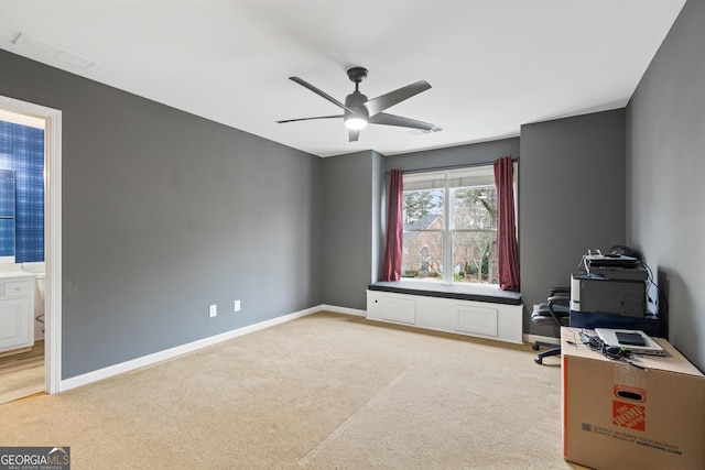 unfurnished office with carpet, ceiling fan, and baseboards