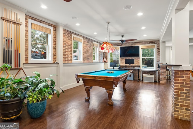 game room with brick wall, ornamental molding, and wood finished floors