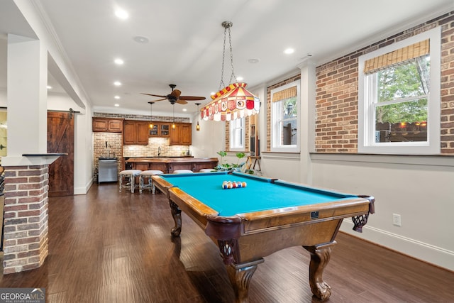 game room featuring a barn door, a ceiling fan, baseboards, dark wood-style floors, and crown molding