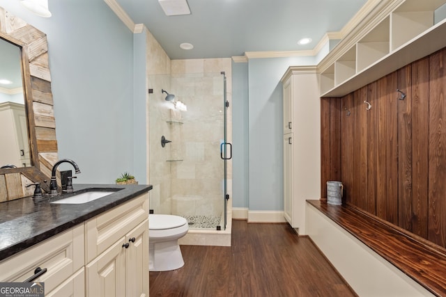 full bath with a stall shower, crown molding, wood finished floors, and vanity