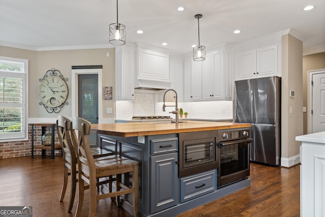 kitchen featuring appliances with stainless steel finishes, white cabinets, wood counters, and dark wood-style floors