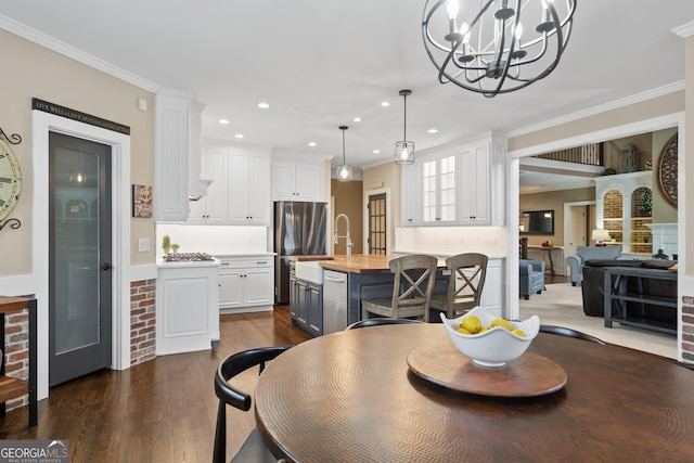 dining room featuring ornamental molding, recessed lighting, dark wood-type flooring, and a notable chandelier