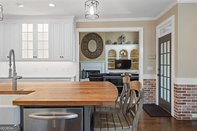 dining room with ornamental molding, a wealth of natural light, a brick fireplace, and dark wood-style floors