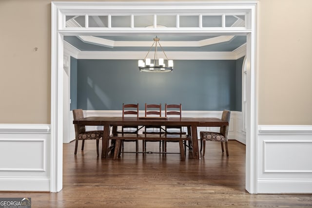 dining room with crown molding, wood finished floors, and a notable chandelier