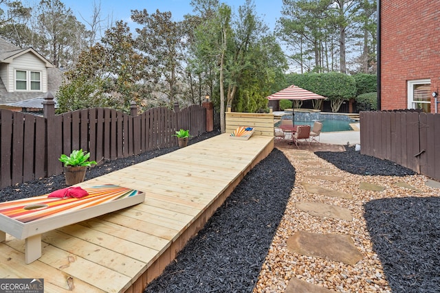 view of yard featuring a wooden deck, a fenced backyard, and a fenced in pool