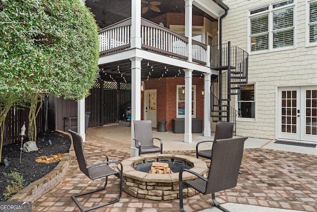 view of patio with stairs, a fire pit, fence, and french doors