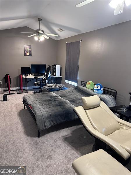 carpeted bedroom with lofted ceiling, ceiling fan, and visible vents