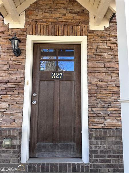 doorway to property featuring stone siding