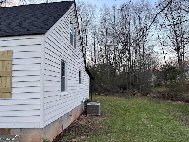 view of side of property featuring a shingled roof, crawl space, a yard, and central AC unit