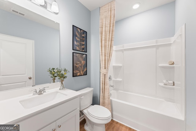 bathroom with visible vents, shower / bathtub combination with curtain, toilet, vanity, and wood finished floors