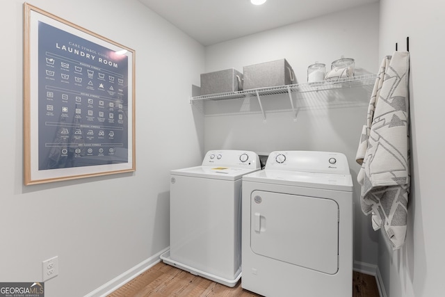 washroom featuring laundry area, baseboards, light wood-style floors, and washer and dryer