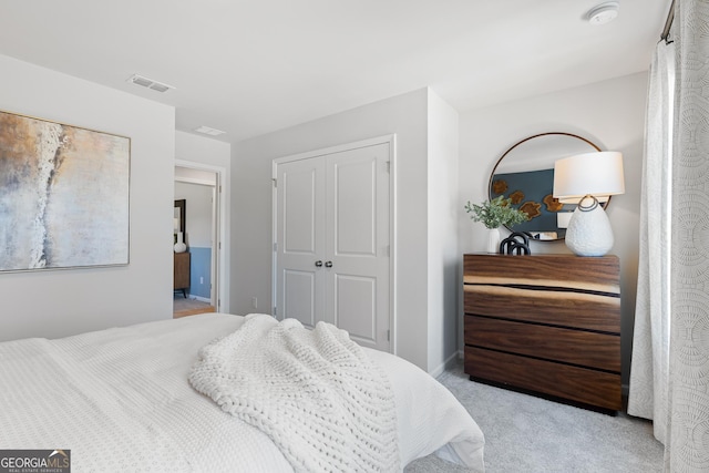 bedroom with baseboards, visible vents, a closet, and light colored carpet