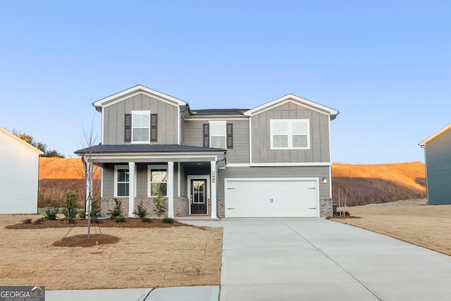 view of front of property featuring covered porch, driveway, board and batten siding, and an attached garage