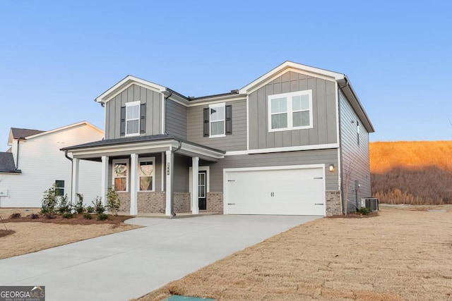 craftsman house featuring a garage, brick siding, board and batten siding, and concrete driveway