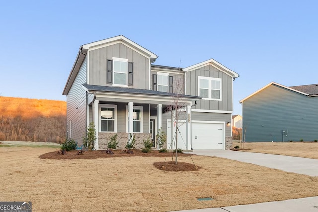 craftsman-style home with board and batten siding, driveway, an attached garage, and a porch