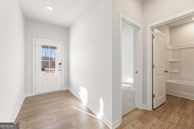 entryway with light wood-style flooring and baseboards