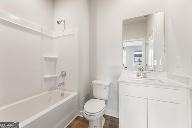 bathroom featuring shower / bathing tub combination, toilet, vanity, wood finished floors, and baseboards