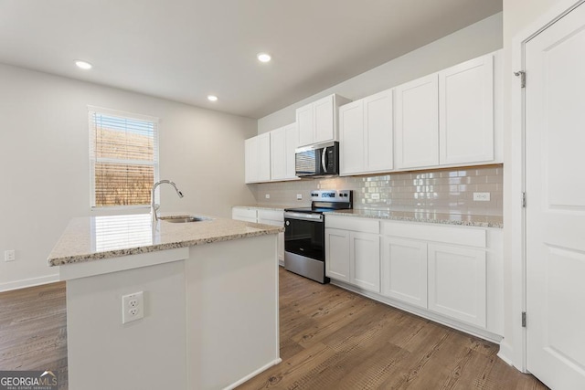 kitchen with a center island with sink, stainless steel range with electric stovetop, and white cabinets