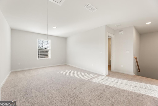 empty room featuring recessed lighting, visible vents, attic access, light carpet, and baseboards