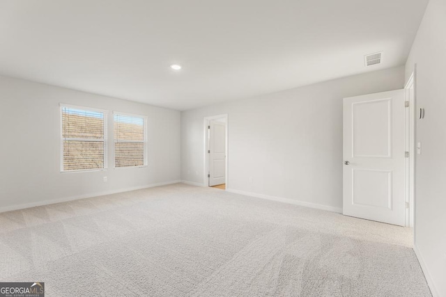 empty room with light colored carpet, visible vents, baseboards, and recessed lighting