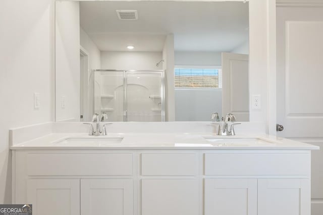 bathroom featuring double vanity, a sink, visible vents, and a shower stall