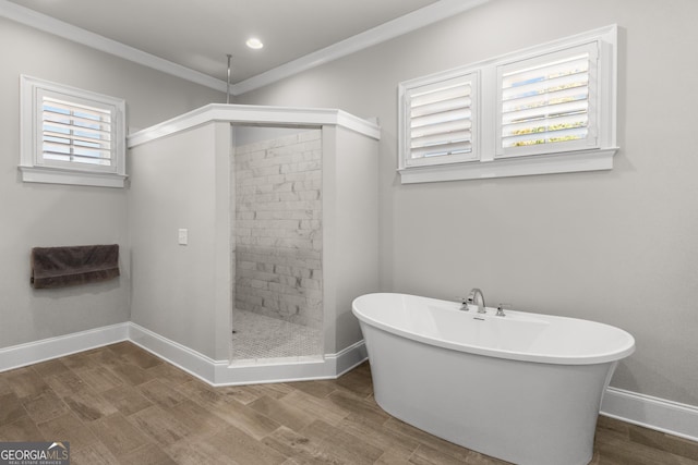 full bath with a soaking tub, a healthy amount of sunlight, baseboards, and wood finished floors