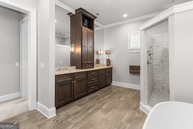 bathroom with ornamental molding, visible vents, a tile shower, and double vanity