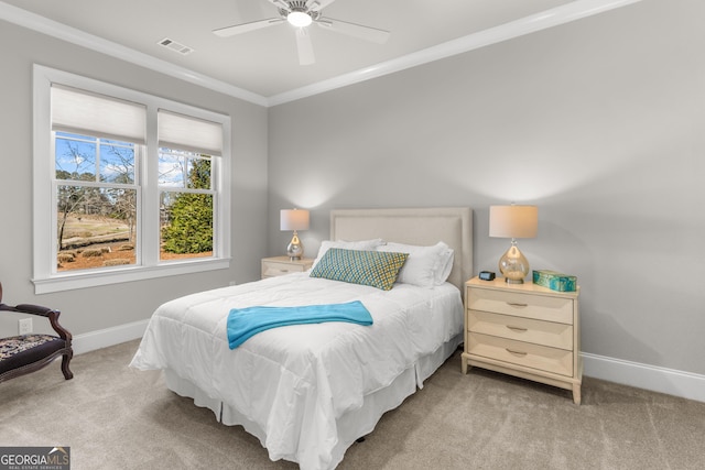 bedroom featuring baseboards, visible vents, crown molding, and light colored carpet