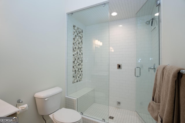 bathroom featuring a shower stall and toilet