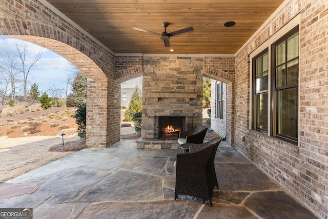 view of patio with ceiling fan and an outdoor stone fireplace