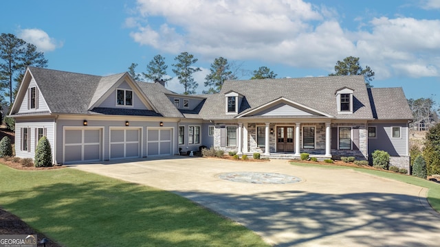 view of front of home featuring a garage, a front yard, concrete driveway, and covered porch