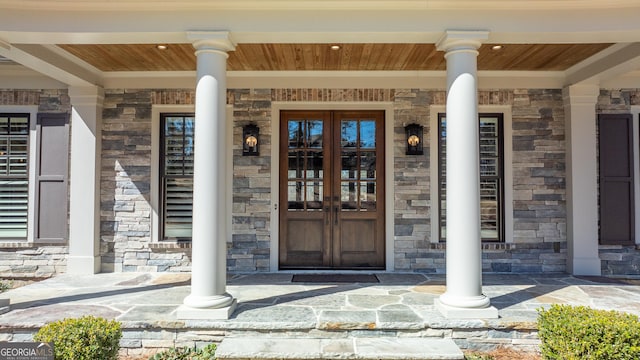 property entrance featuring stone siding and french doors