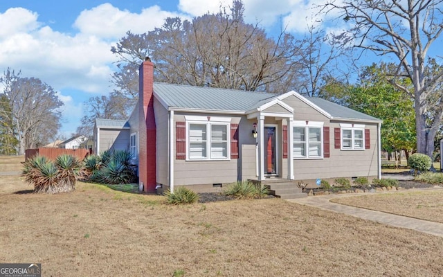 bungalow featuring crawl space, metal roof, a chimney, and a front lawn