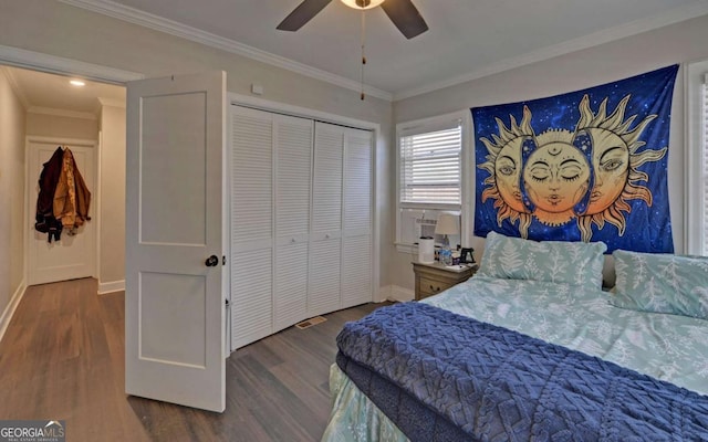 bedroom featuring dark wood-style floors, a closet, baseboards, and crown molding