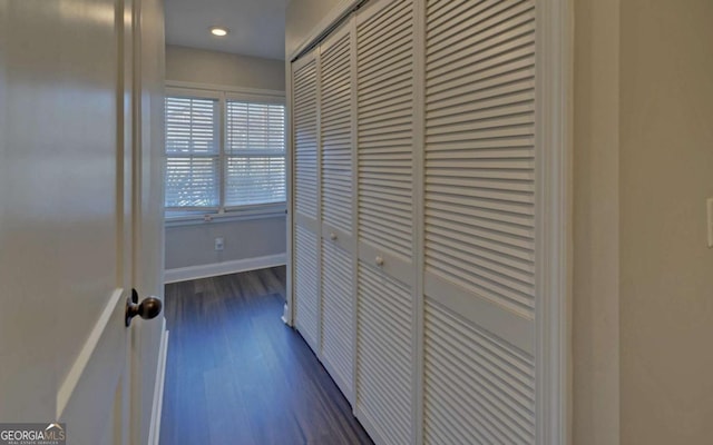 corridor featuring baseboards, dark wood finished floors, and recessed lighting