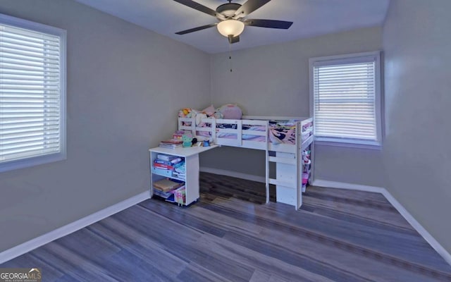 bedroom featuring ceiling fan, baseboards, and dark wood finished floors