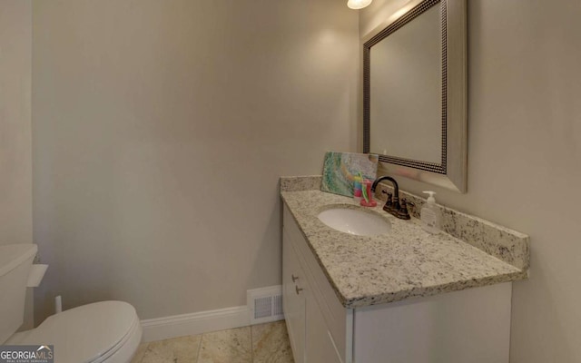 half bath with visible vents, toilet, vanity, baseboards, and tile patterned floors