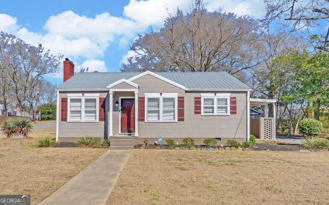 bungalow with crawl space, a chimney, a front lawn, and metal roof