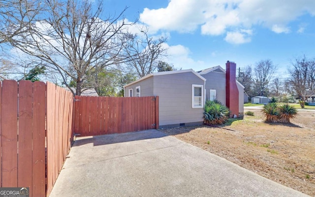 view of home's exterior featuring crawl space, fence, and a chimney