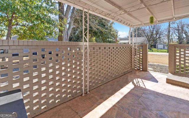 view of patio / terrace with a storage shed and an outdoor structure