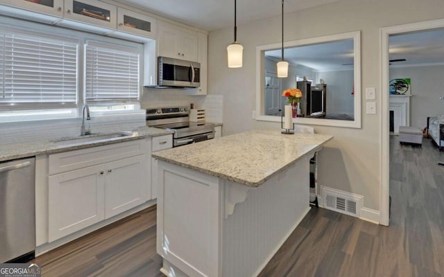 kitchen featuring visible vents, appliances with stainless steel finishes, white cabinets, and a sink