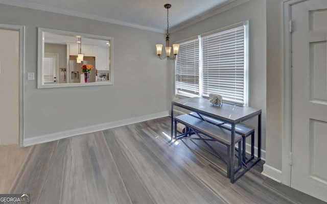 dining area with baseboards, a chandelier, wood finished floors, and crown molding