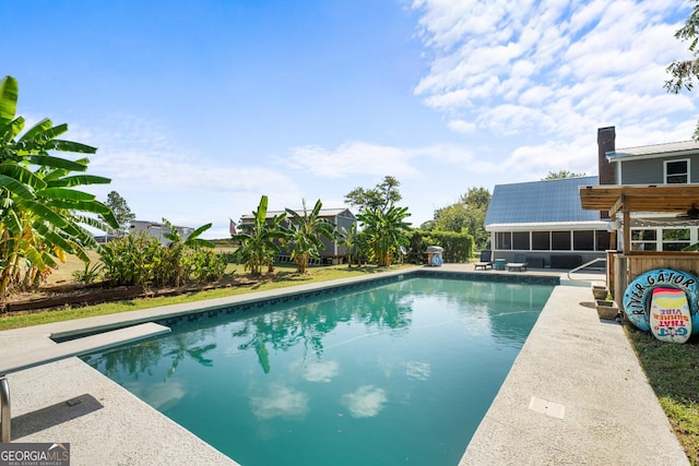 outdoor pool with a sunroom and a patio